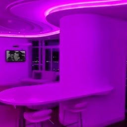 Image of the lounge with purple lighting and showing Sonos wall tablet